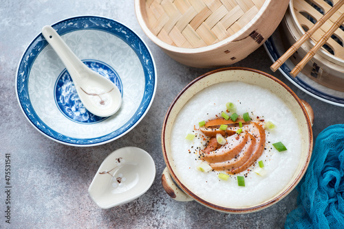 Bowl of asian congee with chicken meat on a roseate metal background, horizontal shot, top view photo