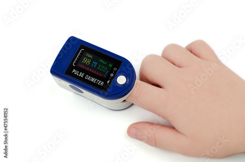 Pulse oximeter on a child's finger on a white background. Saturation 98 and pulse 122 in a child