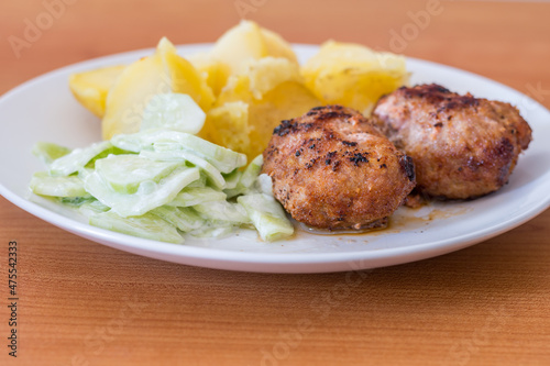 Ground cutlets (kotlety mielone) with mizeria and potatoes.
