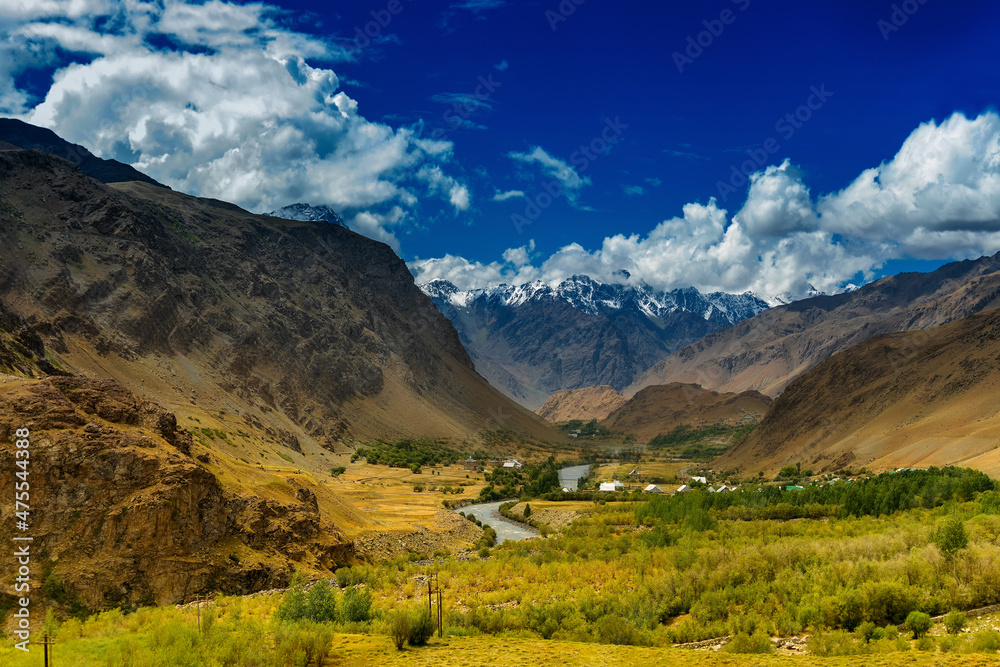 Rocky landscape of Kargil with blue cloudy sky in background , green valley , Ladakh, Jammu and Kashmir, India