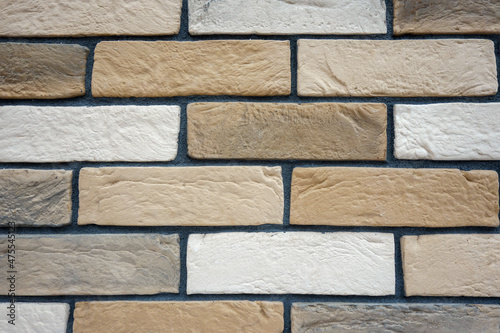 Multi-colored brick wall with dark gray seam.