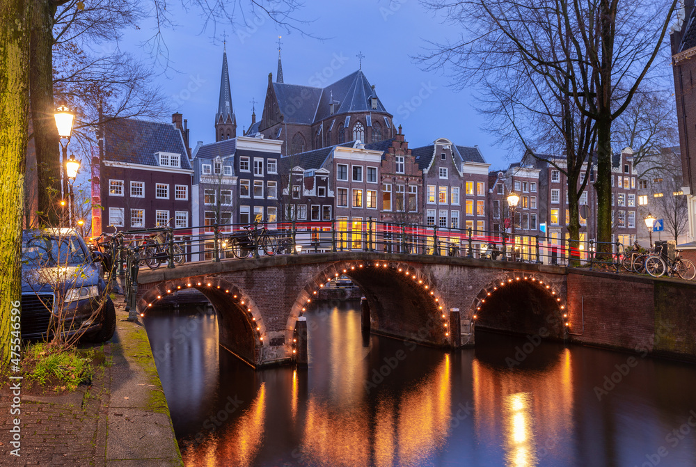 Beautiful old houses on the city waterfront of Amsterdam at sunset.