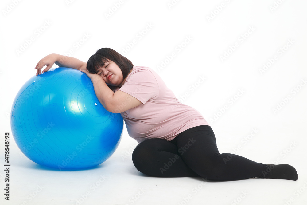 Fat Asian woman tired from exercise Lie on a blue yoga ball on a white background. weight loss exercise concept to have good health Fat Asian woman tired from exercise Lie on a blue yoga ball on a white background. weight loss exercise concept to have good health