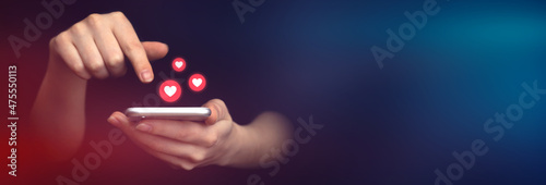 Social media concept, banner. Hands using smartphone with like notification icons. Social networking, black background photo