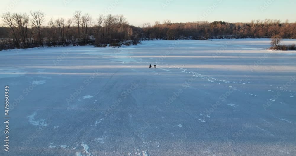 Two people are skating on a frozen lake. Aerial view Two people are skating on a frozen lake. Aerial view