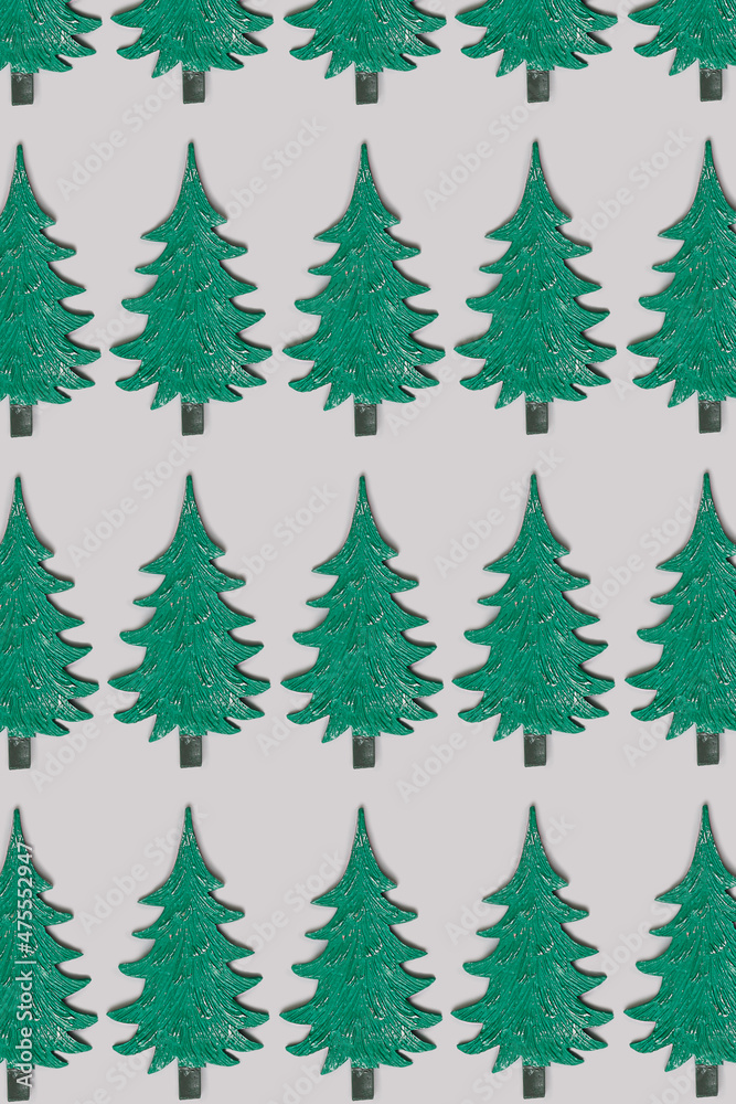Christmas pattern concept made of green toy Christmas tree on very peri purple background. Minimal New Year holiday idea. Creative top view wallpaper. Flat lay with copy space.