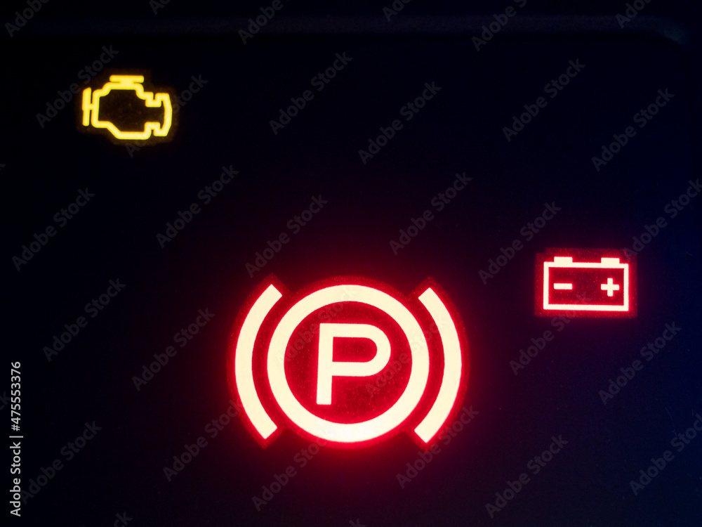 Red illuminated hand brake sign close-up. Red illuminated hand brake sign close-up.