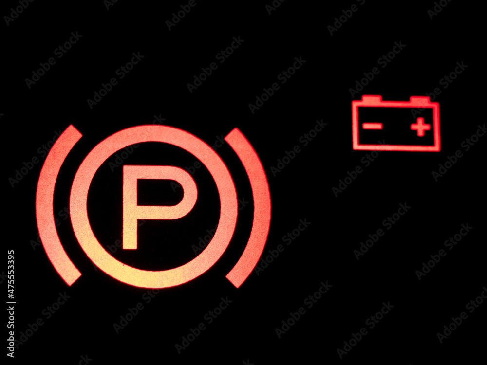 Red illuminated hand brake sign close-up. Red illuminated hand brake sign close-up.