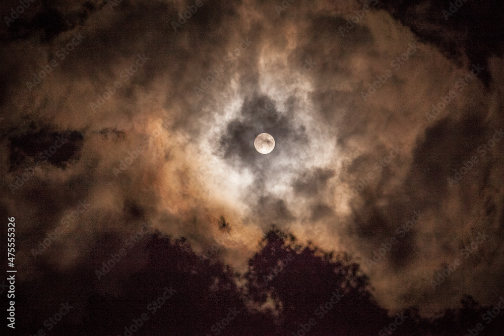 Full moon peeking through the clouds. Full moon peeking through the clouds.