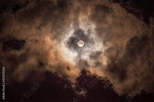 Full moon peeking through the clouds.