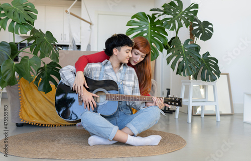 Lesbian couple with guitar in room