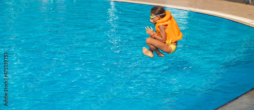 The child jumps into the pool. Selective focus.