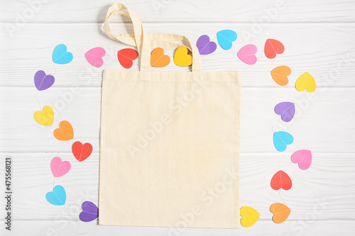 Valentines mockup tote bag with paper colorful hearts on white wooden background, flat lay, top view, copy space. photo