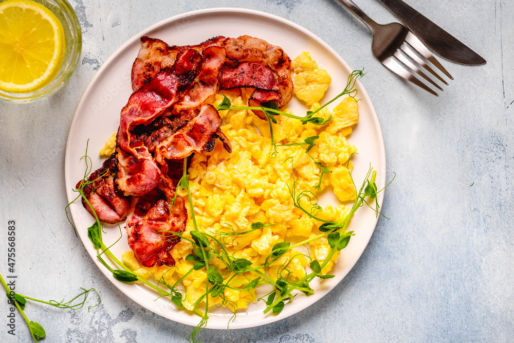 Traditional breakfast scrambled eggs with fried bacon Traditional breakfast scrambled eggs with fried bacon