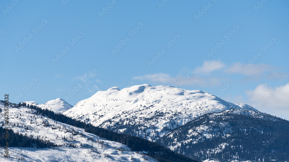huge mountains covered by snow and sunny sky with clouds british columbia canada