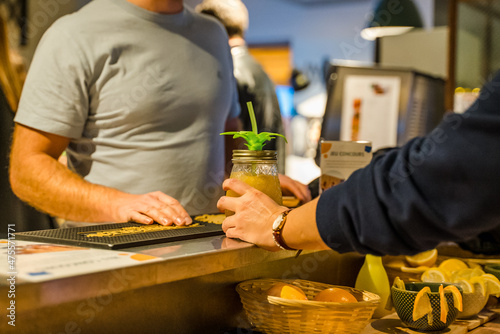 Une serveuse sert un cocktail à un client dans un bar photo