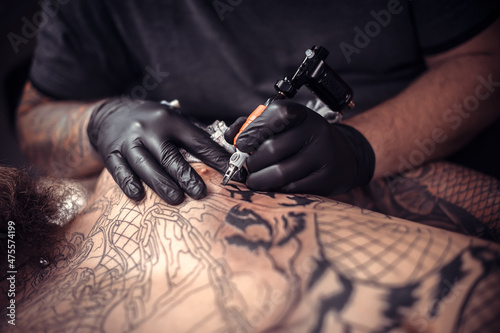 Fotografie, Obraz Professional tattooer does a tattoo in the Studio