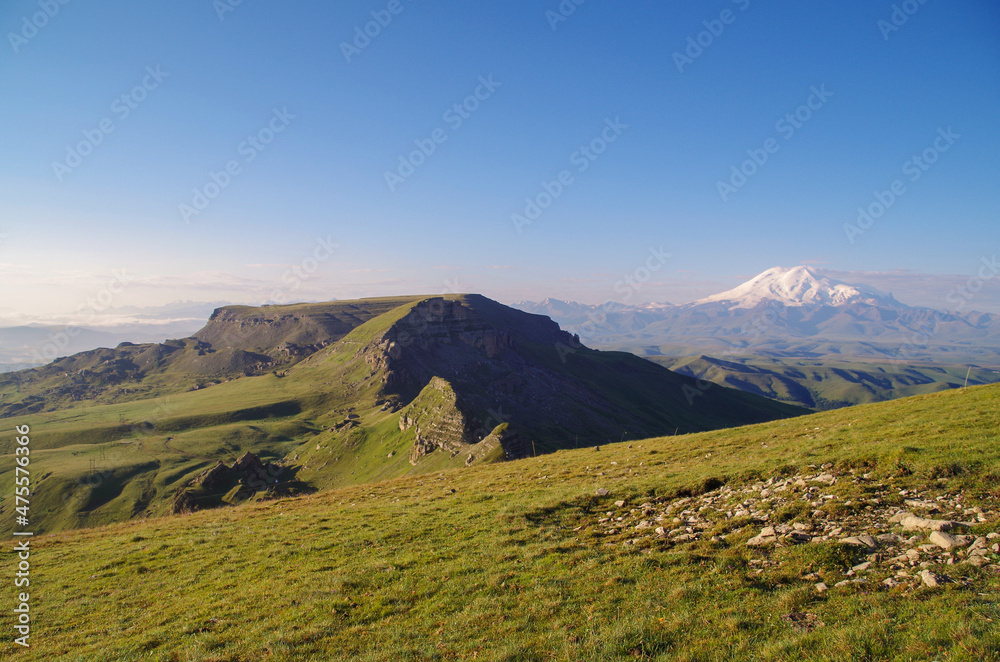 Sunrise over the Bermamyt Plateau. Scenic view of two summits of Mount Elbrus on horizon. Mt Elbrus - highest and most prominent peak in Russia and Europe. Russia, Caucasus, Karachay-Cherkessia Sunrise over the Bermamyt Plateau. Scenic view of two summits of Mount Elbrus on horizon. Mt Elbrus - highest and most prominent peak in Russia and Europe. Russia, Caucasus, Karachay-Cherkessia