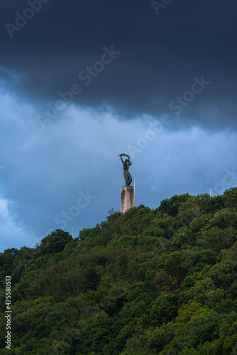 Vertical shot of a statue at Gellert hill before a storm in Budapest, Hungary photo