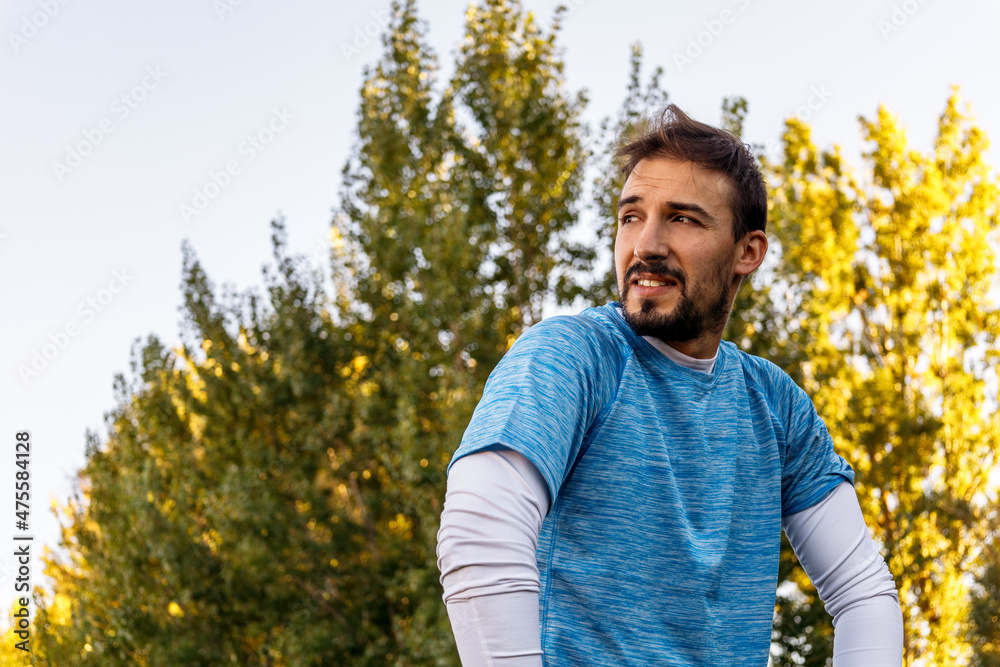 portrait of caucasian man in park with sportswear over a tree portrait of caucasian man in park with sportswear over a tree
