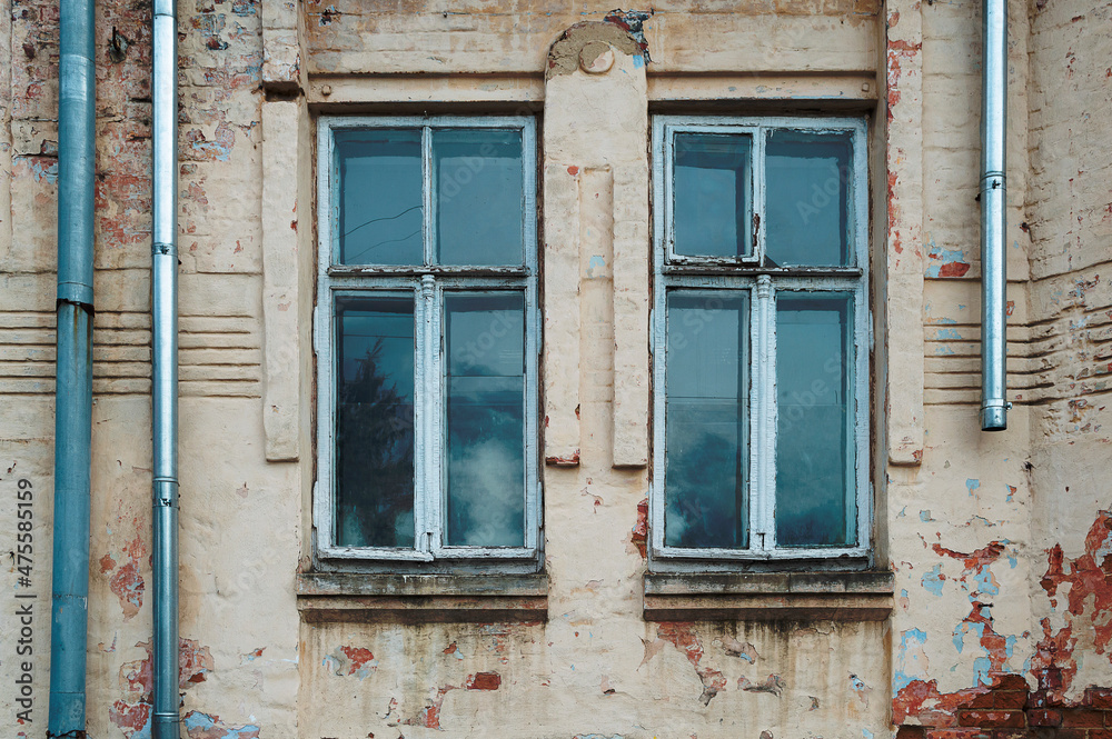 ruined and abandoned house exterior. Abandoned house. Broken glass in the window and falling plaster.