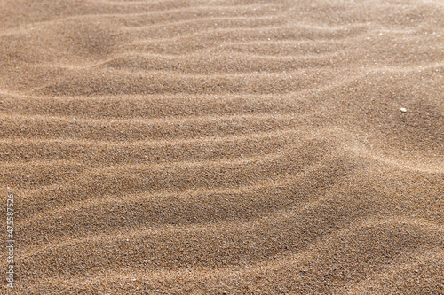 Close-up of sand on the beach with wave form produced by the wind