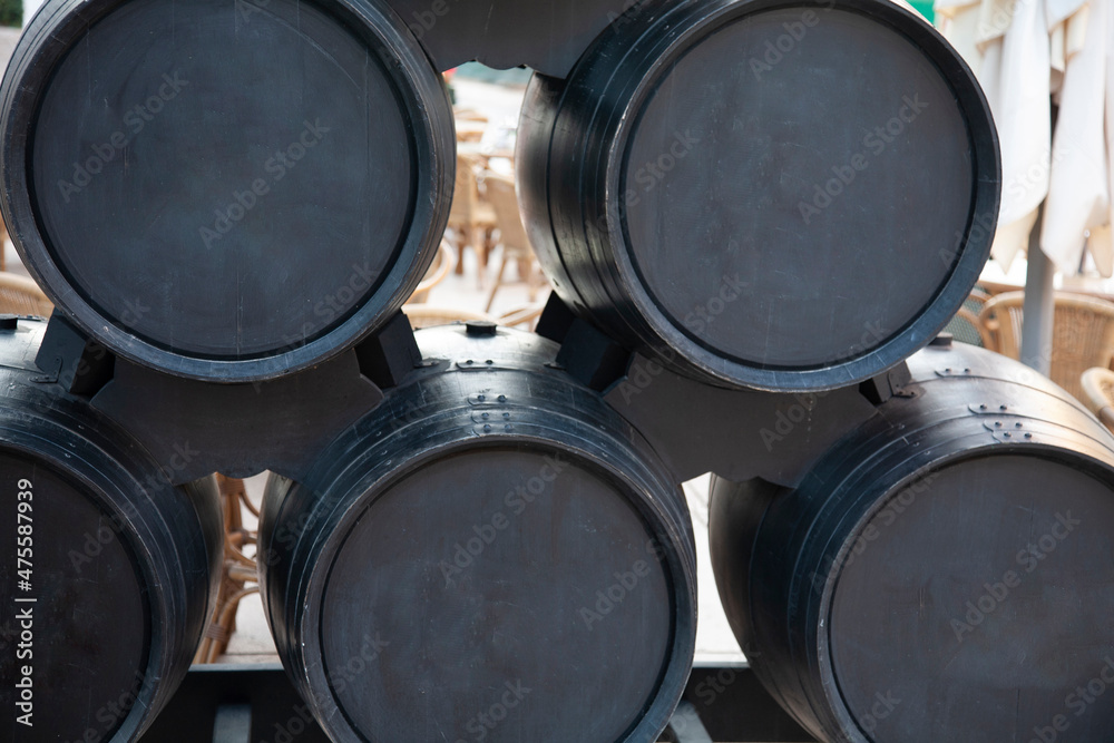Stack of black barrels. Five barrels in two rows. Typical sherry wine Stack of black barrels. Five barrels in two rows. Typical sherry wine