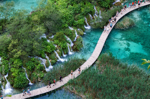 Aerial view at wooden hiking path through water besides waterfalls in Plitvice Lakes National Park, Croatia photo