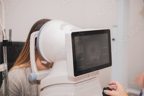an optometrist uses a wide cone corneal topographer to take information from a patient's cornea.