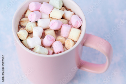 close up of a pink mug with hot chocolate and a lot of mini marshmallows inside