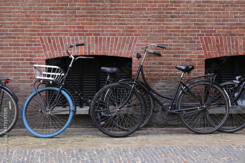 Parked Bicycles against a Brick Wall in Amsterdam, Netherlands © Monica