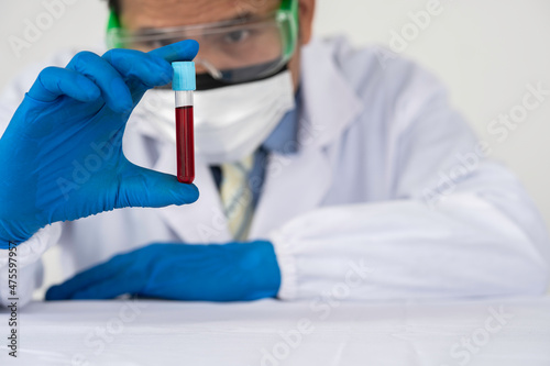 lab technician assistant analyzing a blood sample in test tube at laboratory. Medical  pharmaceutical and scientific research and development concept.