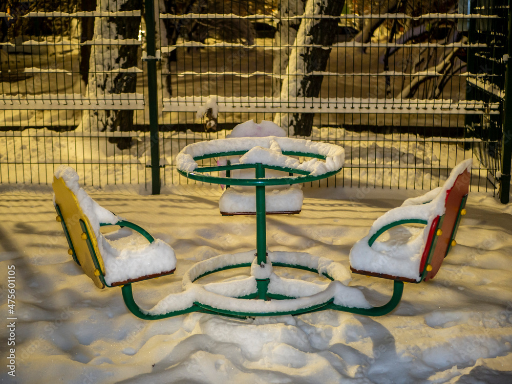 children's carousel covered with snow. evening photo. low light children's carousel covered with snow. evening photo. low light