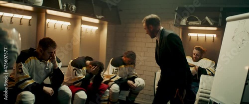 Angry disappointed coach yelling on players of ice hockey team in the locker room. Shoot with 2x anamorphic lens