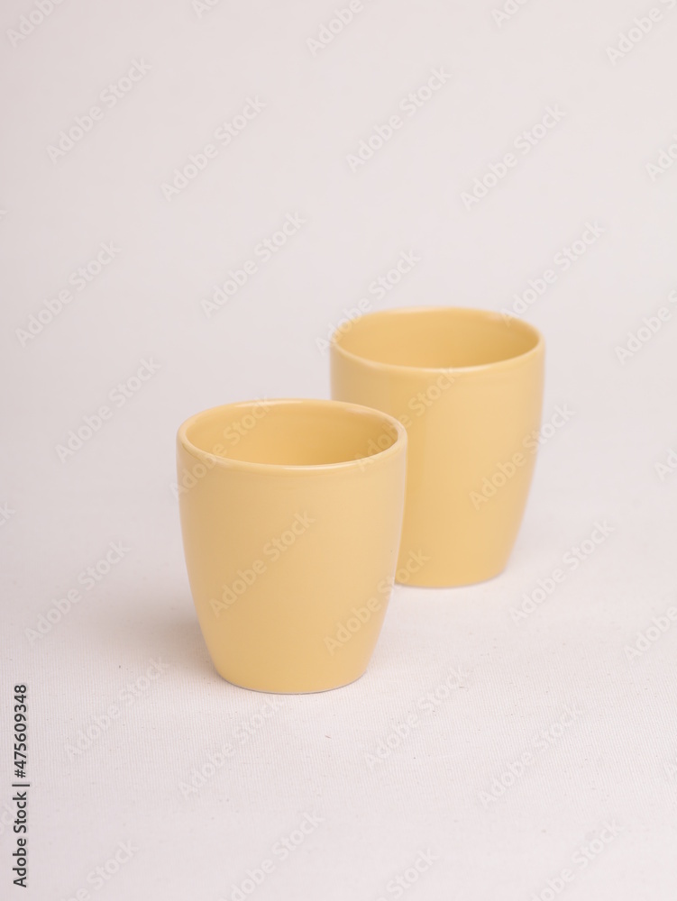 yellow ceramic cup on a light background yellow ceramic cup on a light background