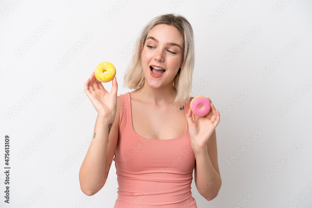 Young caucasian woman isolated on white background holding donuts with happy expression Young caucasian woman isolated on white background holding donuts with happy expression