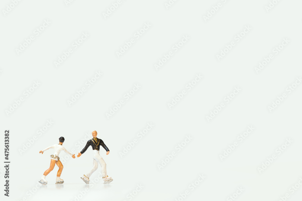 Miniature figures of ice skaters on a white background Stock Photo