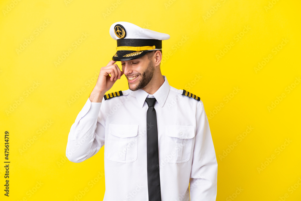 Airplane caucasian pilot isolated on yellow background laughing