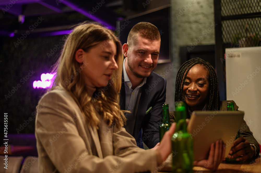 Cheerful colleagues drinking beer in the bar together after work