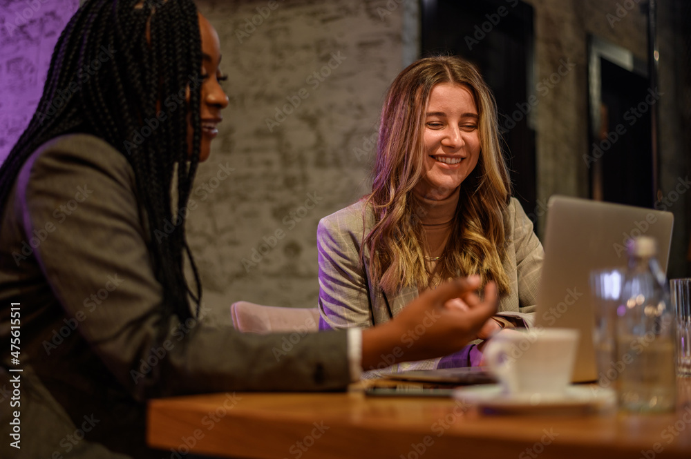 Two businesswoman having a meeting in a cafe while using a laptop Two businesswoman having a meeting in a cafe while using a laptop