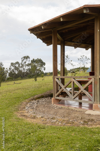 wooden structure for barbecue area in park with grass and trees, nature as landscape, country lifestyle