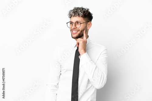 Business caucasian man isolated on white background thinking an idea while looking up © luismolinero