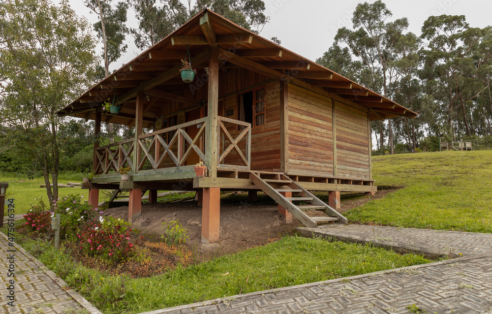 landscape with one wooden cabin with balcony, rustic style with garden and grass around it, background with trees in the day, lifestyle in the country, architecture and nature landscape with one wooden cabin with balcony, rustic style with garden and grass around it, background with trees in the day, lifestyle in the country, architecture and nature