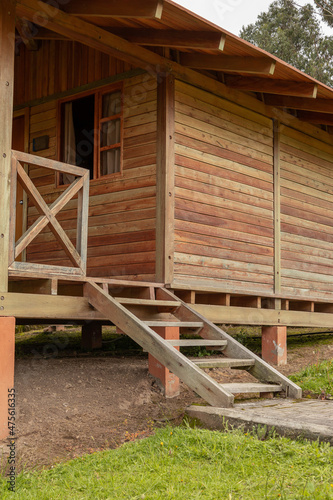 Fotografía rustic wooden cabin with balcony and stairs, detail of the facade, structure in