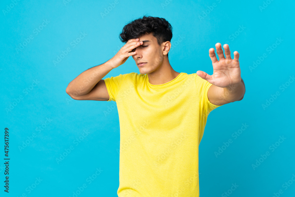 Young Argentinian man isolated on background making stop gesture and covering face Young Argentinian man isolated on background making stop gesture and covering face
