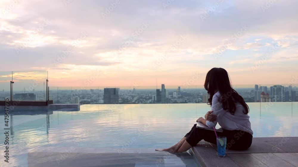 Happy asian woman relaxing with laptop sitting on the edge dangling her ...