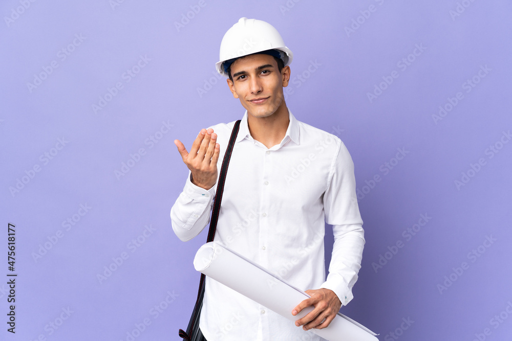 Young architect man isolated on background inviting to come with hand. Happy that you came Young architect man isolated on background inviting to come with hand. Happy that you came
