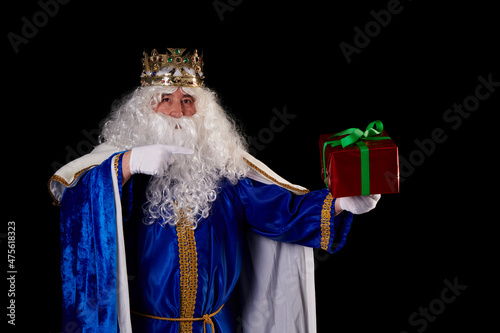 A magician king with a present on a black background