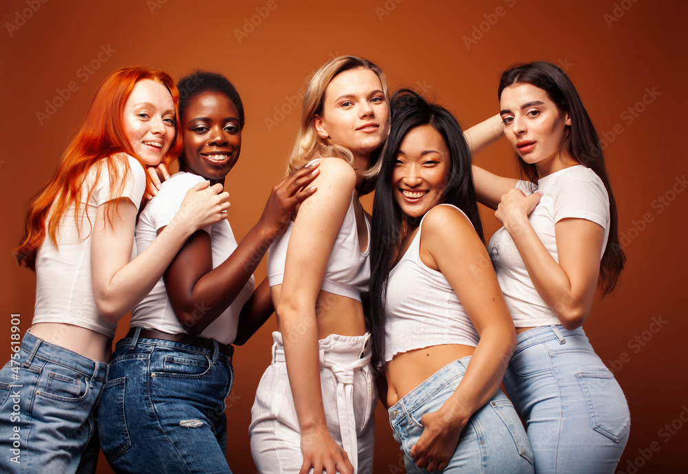 young pretty african and caucasian women posing cheerful together on brown background, lifestyle diverse nationality people concept young pretty african and caucasian women posing cheerful together on brown background, lifestyle diverse nationality people concept