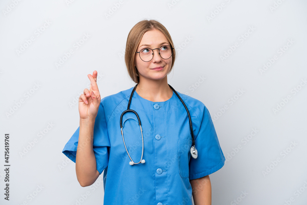 Young nurse doctor woman isolated on white background with fingers crossing and wishing the best Young nurse doctor woman isolated on white background with fingers crossing and wishing the best